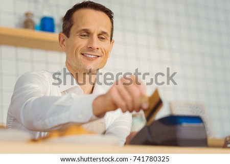 Delighted nice man holding a credit card