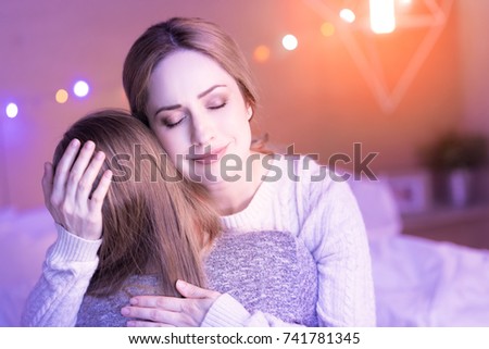 Pleased mum hugging her daughter