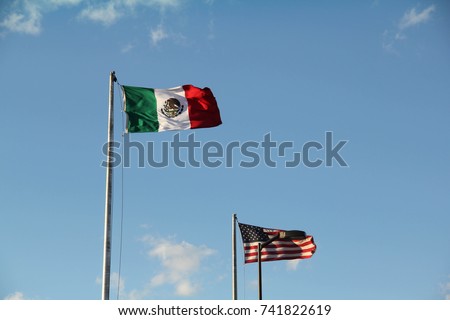 A Mexican flag and a flag of the United States of America, marking the border between Ciudad Juarez, Mexico, and El Paso, Texas Royalty-Free Stock Photo #741822619