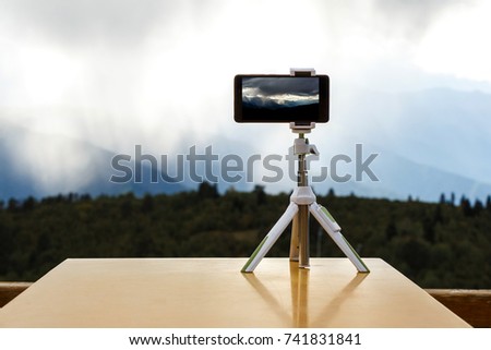 smartphone on a tripod in the mountains, a storm against the background