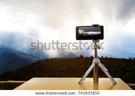 smartphone on a tripod in the mountains, a storm against the background