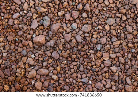 Surface of red rocks dirt and pebbles lay on the floor. It was crushed and cracked. Use for background or banner website and template.