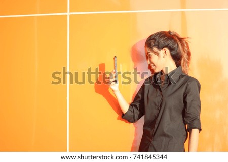 Portrait of a smiling and cheerful asian woman making selfie photo on smartphone.
