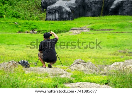 Male Photographer taking a Landscape picture of mountain.