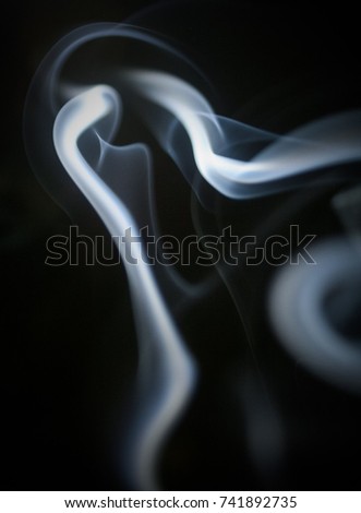 A blue waft of smoke flowing over a black background.