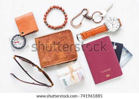 Travel and holiday concept with men's accessories travel items and pocket money on white rustic wooden board background