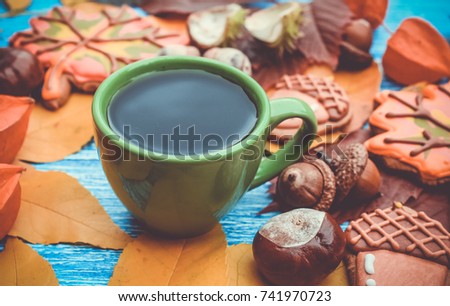 maple, chestnuts leaves with cup of coffee or tea on wooden table.Thanksgiving day style