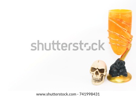 Orange glass with bone hand design with small skull on white background isolated
