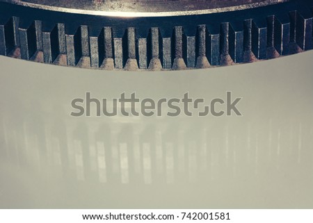 Gear wheel on reflective surface close-up. Pattern. Vintage mechanism. Retro device.