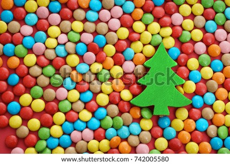 green  wooden christmas tree and round circle colorful Candy around . holiday and sweet food background. happy new year