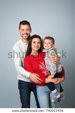 Happy couple with son on light background