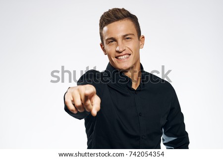 business man smiling showing his finger in the camera on a light background                               