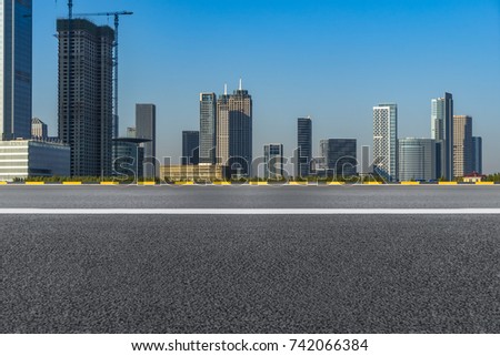 empty asphalt road front of modern buildings under blue sky