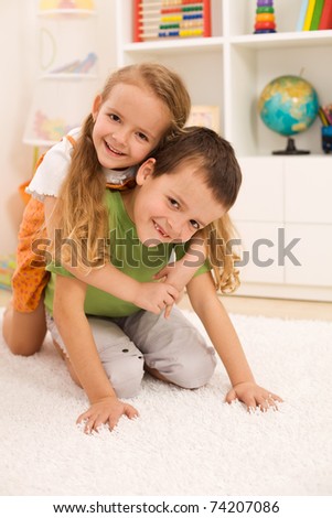 Little boy anf girl wrestling and having fun in their room