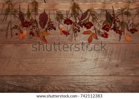 Autumn arrangement of colorful leaves and autumn flowers on a wooden background with free space for text. Top view, season concept, toned retro effect, flat lay