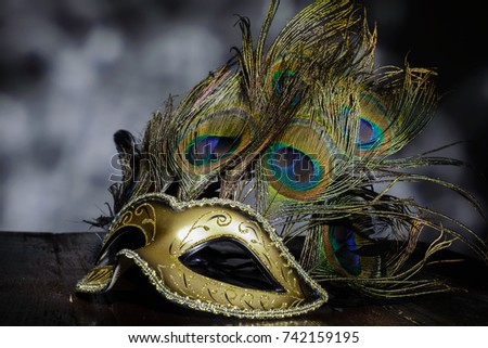 carnival venetian mask with peacock feathers on dark background.