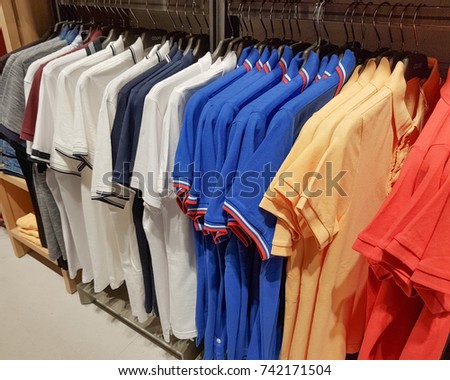 Multicolored T-shirts on hangers. Order in the closet. Wardrobe.