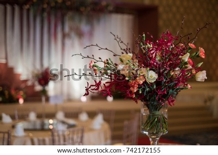 Original wedding floral decoration in the Ball room and bouquets of red flowers. 