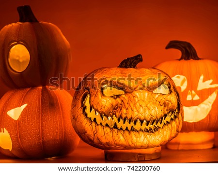 The decoration of the scary orange pumpkins with light on the shelf. The decoration of Halloween night at the end of October.
