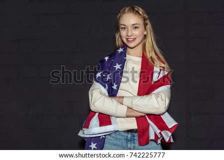 teen girl with crossed arms wearing usa flag on black