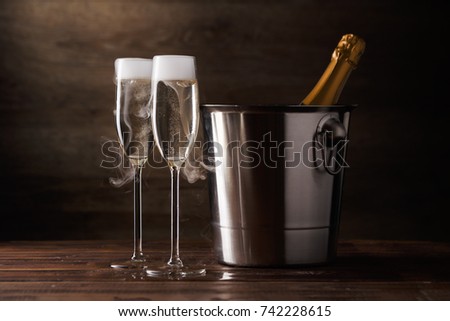 Image of two wine glasses with sparkling wine, iron bucket