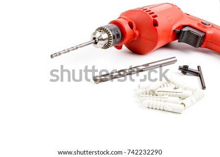 Set Red Small Electric drill machine with drill bit , Chuck keys and Plastic or rubber anchors for concrete work isolate on white background.