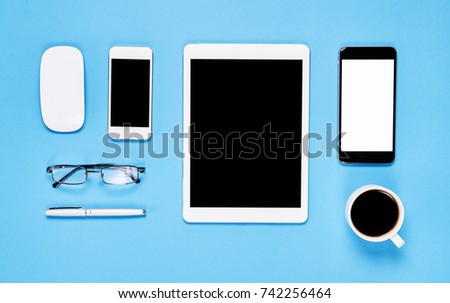 Top view, Modern workplace with laptop and tablet with smart phone placed on a pastel yellow background. Copy space suitable for use in graphics.