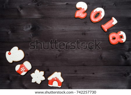 Happy new year 2018 sign symbol from red and white gingerbread cookies on dark wooden background, copy space. Top view, flat lay. Christmas cookies, free space