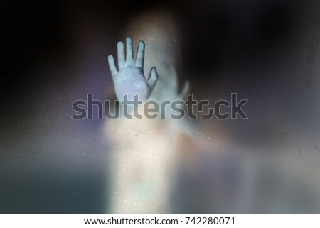 Soft shutter haunted of ghost hands behind the frosted glass negative film style, Halloween, Dia De Muertos concept.