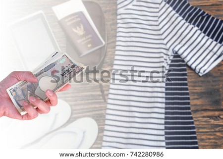 hand woman with Japanese currency yen bank notes on blurred background travel cost, travel accessories woman costumes prepare for trip.