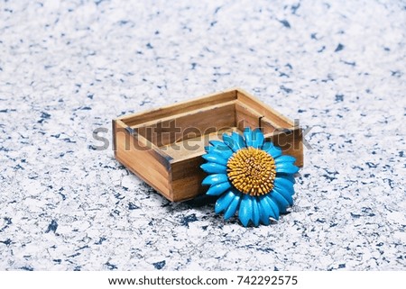 Wooden gift box and blue flower decoration closeup blur texture background