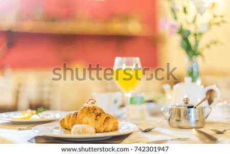 Croissant on a plate. Table set with breakfast.