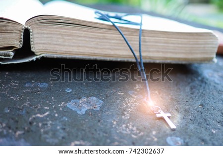 Closeup of wooden Christian cross on bible