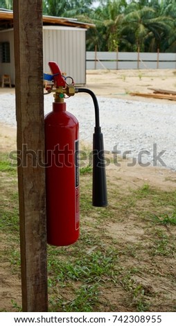 Carbon dioxide portable fire extinguisher hanging on timber at construction site