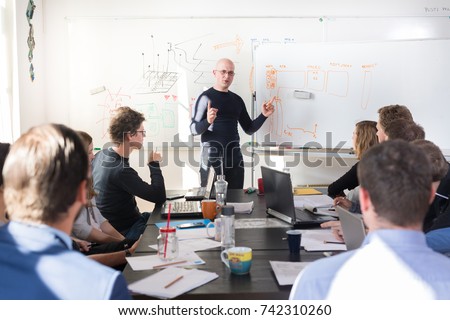 Relaxed informal IT business startup company meeting. Team leader discussing and brainstorming new approaches and ideas with colleagues. Startup business and entrepreneurship concept. Royalty-Free Stock Photo #742310260
