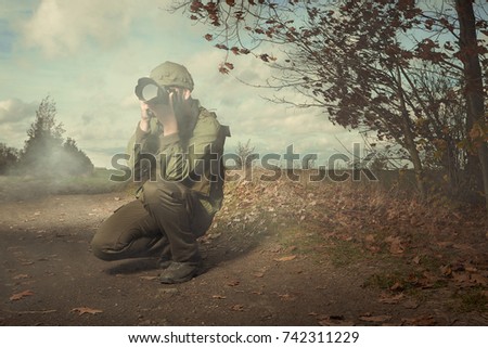 Photographer in war conflict field zone taking pictures