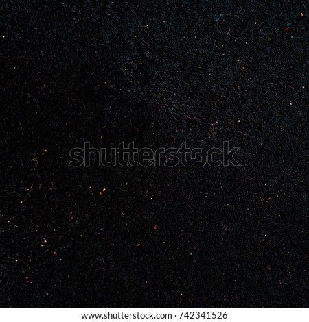 Black asphalt surface. Closeup of dark grunge texture with grain, may use as background with copy space