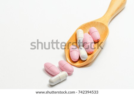Medicine on a wooden spoon and on a white background