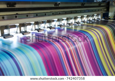 Large Inkjet printer working multicolor cmyk on vinyl banner Royalty-Free Stock Photo #742407358
