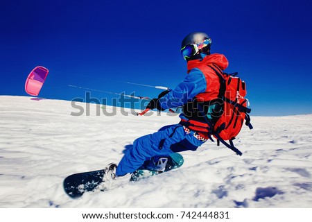 Snowboarder. Snowboard with snow kite against a blue sky. Concept outdoor extreme activities in winter snowkite Royalty-Free Stock Photo #742444831