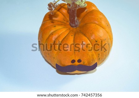 Halloween pumpkin is decorated with mustache