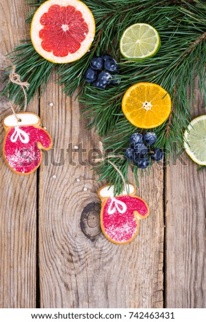 Homemade gingerbread cookies glazed and christmas tree branches with fruits. Studio Photo