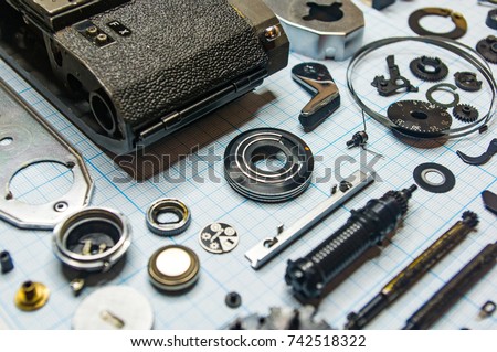 parts are completely disassembled old retro film SLR camera on graph paper, close-up
