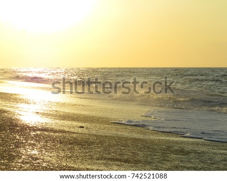 Sunset over water waves and beach. warm light, peaceful and relaxing. Norfolk UK