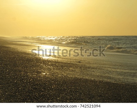 Sunset over water waves and beach. warm light, peaceful and relaxing. Norfolk UK