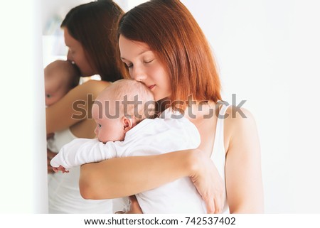 Portrait of Mother and Baby. Beautiful woman holding a baby child in her arms. Image of happy maternity and family.