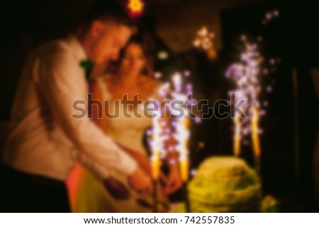 newlyweds cut a birthday cake. blurred image of bride and groom cutting wedding cake. beautiful newlyweds cutting stylish cake, celebrating wedding. wedding day. blurred image / soft focus