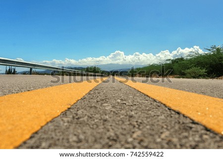 yellow dividing lines on asphalt road or highway close-up