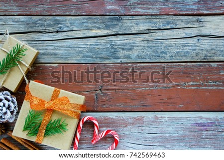 Rustic wooden background with Christmas Box, Pine Cone, Candy Canes, Cinnamon Sticks. Flat Lay Holiday Greeting Card