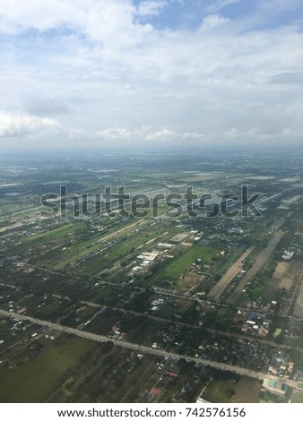 Picture of Wet fields under cloudy sky taken from an airplane